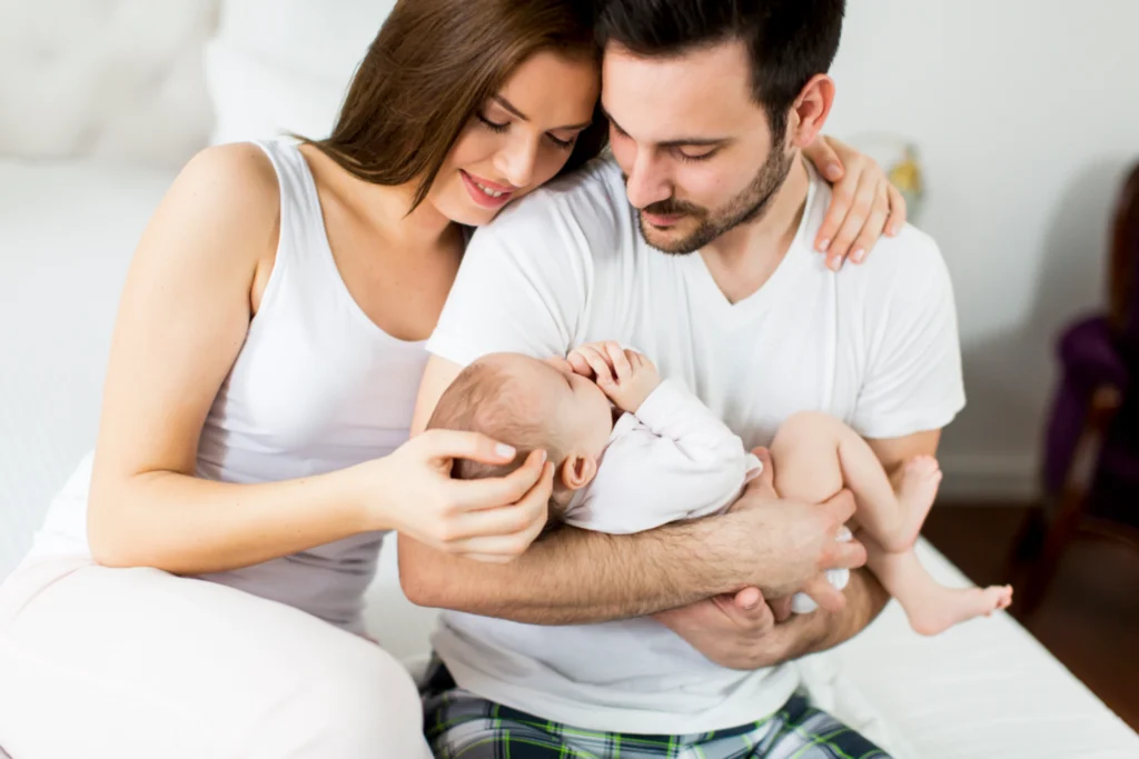 Parents holding and looking lovingly at their newborn baby